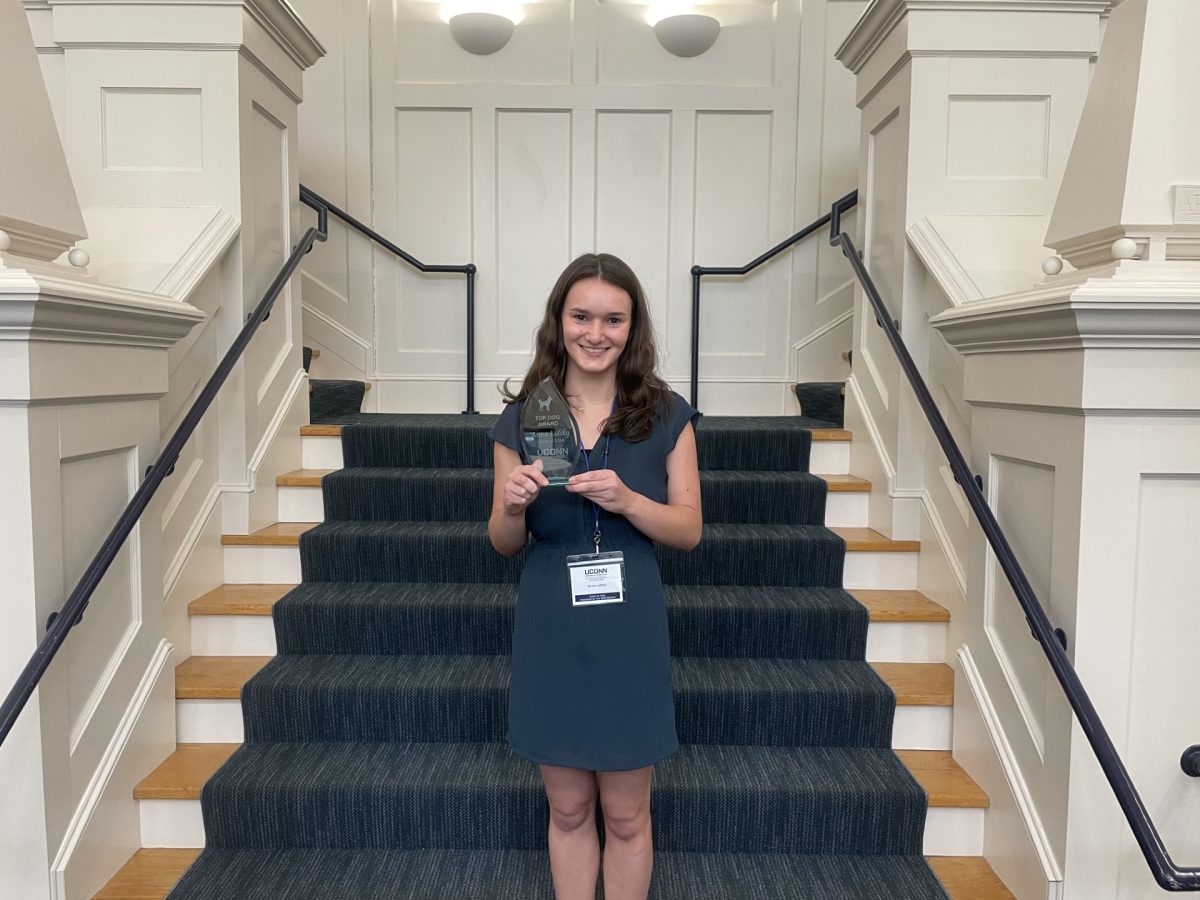 Anna Lidsky stands in front of stairs with award.