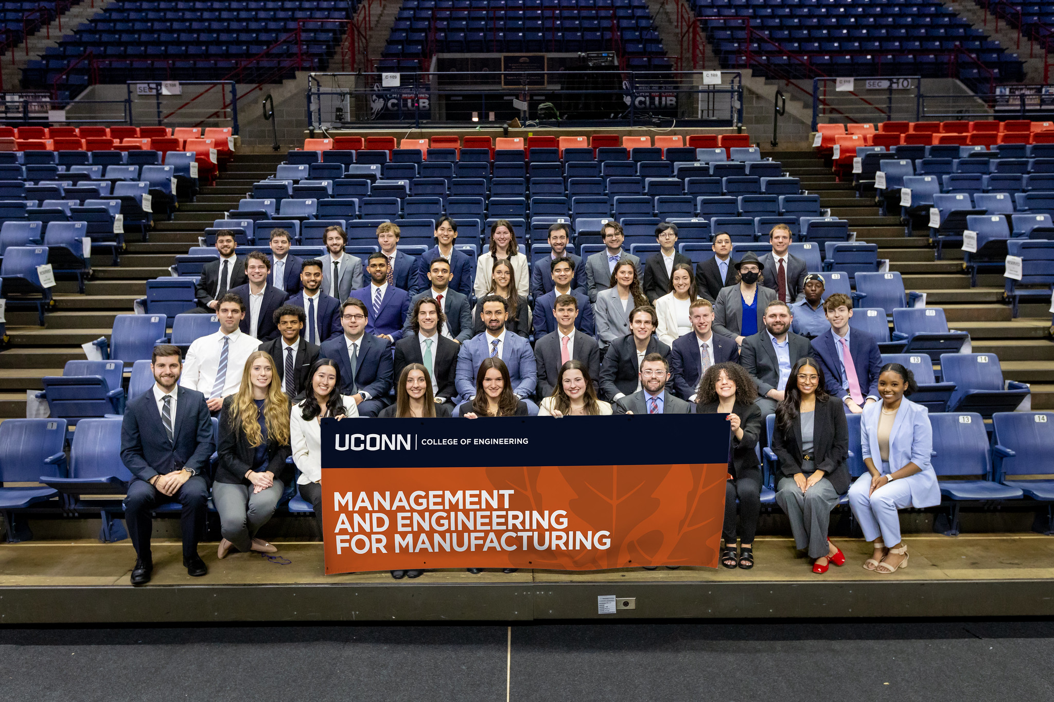 MEM students at Demo Day 2024 sitting together with an MEM banner.